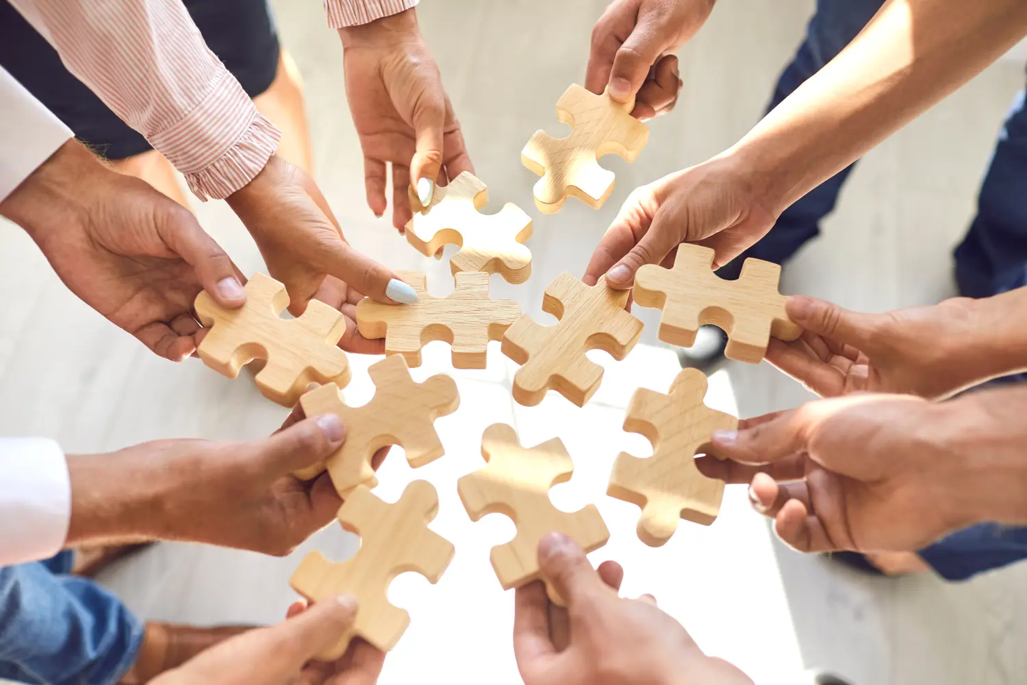 Mitarbeiter des Unternehmens spielen ein Spiel und fügen Puzzleteile während einer Teambuilding-Aktivität zusammen